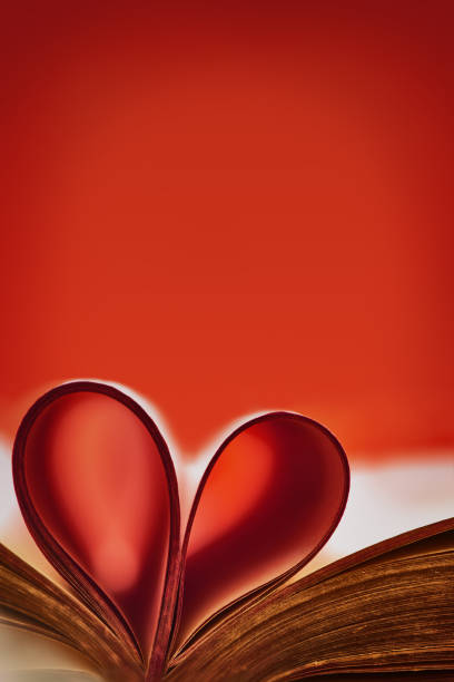 istock Abstract background with red accent. Old book. An open book with a heart folded from folded sheets. Love education concept.Copy space 1304307596