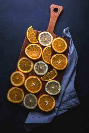 Citrus fruit on cutting board, flat lay, from above.