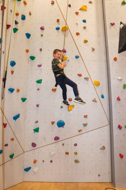 istock Young boy climbing with rope on climbing wall 1304311248