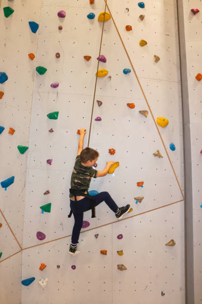 istock Young boy climbing with rope on climbing wall 1304311327