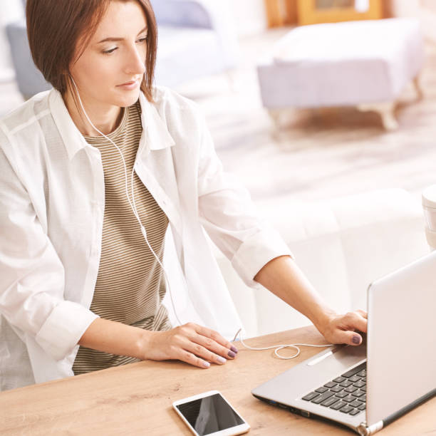 istock Young woman sitting at home. Working on notebook 1304312528