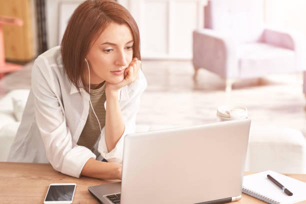 istock Young woman sitting at home. Working on notebook 1304312533