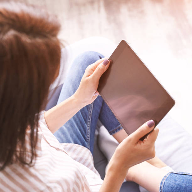 istock Young woman sitting at chair. Working on tablet. Online study concept 1304312541