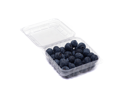 Blueberries in a plastic container on a white background. Macro