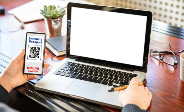 istock Coronavirus immunity vaccination concept. Man working with a blank screen laptop, office background, Border control pass, 1304315332