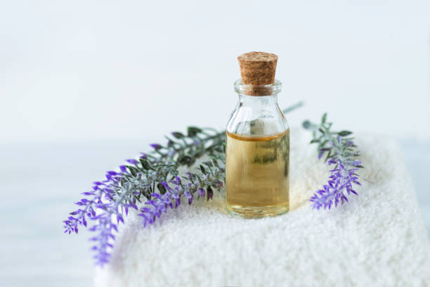 Lavender Front view of lavender in oil and  lavender flowers on a white towel on marble background. lavender plant photos stock pictures, royalty-free photos & images