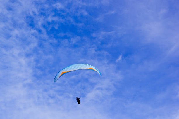 낮에는 밝은 구름이 많고, 언덕에서 스카이다이빙을 하는 관광객이 있습니다. - skydiving base jumping extreme sports mountain 뉴스 사진 이미지