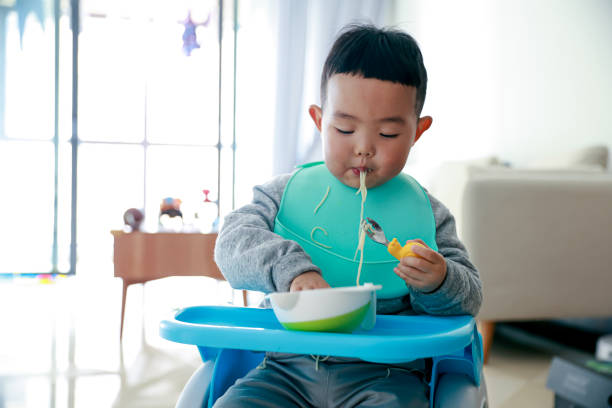 Asian baby boy eating noodle Asian baby boy eating noodle chinese ethnicity china restaurant eating stock pictures, royalty-free photos & images
