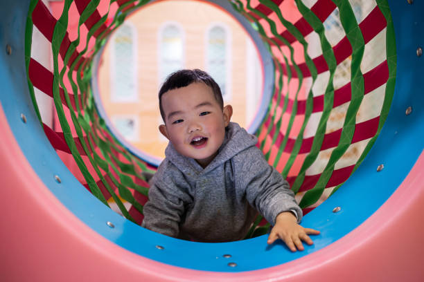 istock Baby boy climbing over in playground tunnel 1304331158