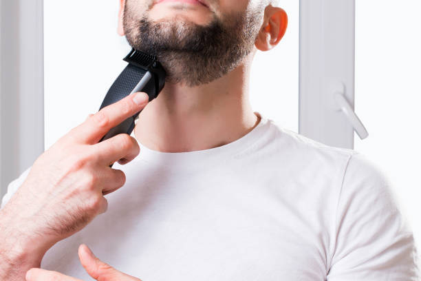 istock A man shaves his beard with a trimmer close-up 1304331378