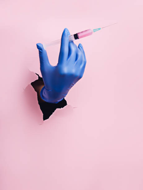 Hand with syringe breaking in through a black hole on yellow background
