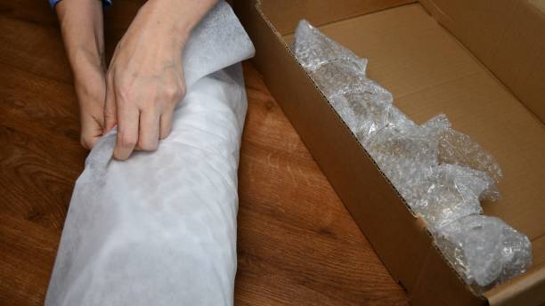 istock Female hands wraps glassware into soft packing wrapping 1304334881