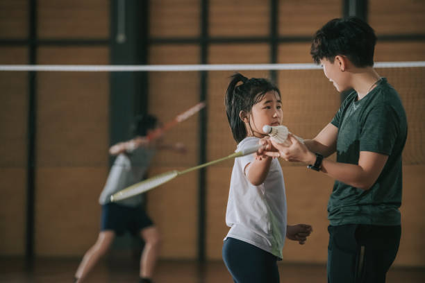 istock asian chinese female trainer guiding her student practicing posture in badminton court 1304335524