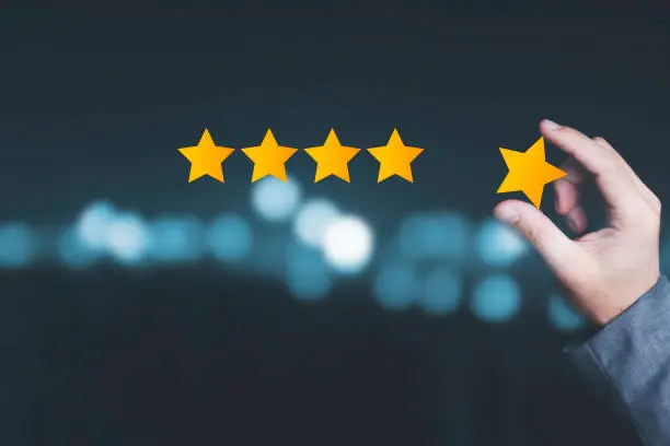 Photo of Customer satisfaction and product service evaluation concept , Hand holding and put yellow star to five stars with copy space.