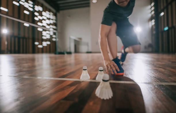 Low angle asian chinese badminton players practicing in badminton court endurance training