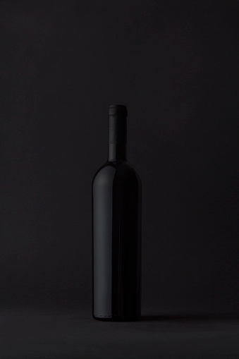 red bottle of wine on moody background