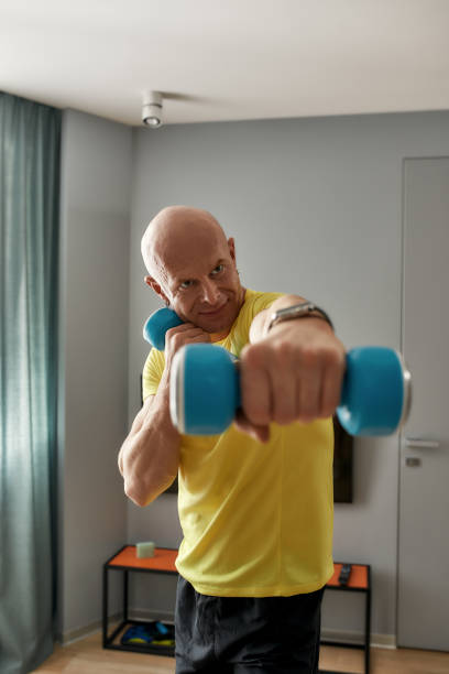 istock Trainer exercising with dumbbells at home 1304340453