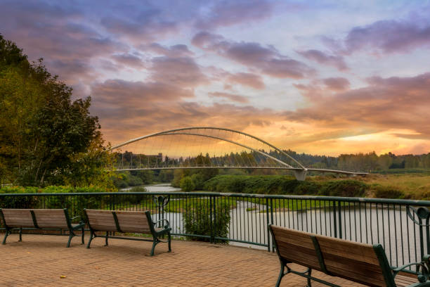 Park benches along Willamette River at Riverfront City Park in Salem OR sunset stock photo