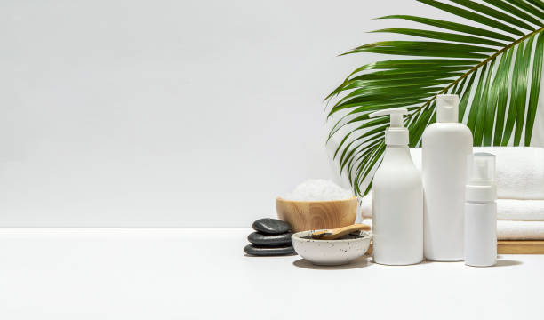 istock White cosmetic bottles with spa element and towel with coconut leaf on white background. 1304342067