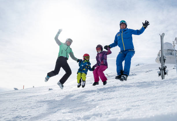 istock Happy ski family having fun jumping on the snow 1304343073
