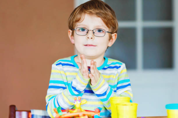 istock Smiling preschool kid boy having fun with dough, colorful modeling compound clay. Creative leisure with children. during corona virus quarantine staying at home. Shelter in place, lockdown concept, 1304343244