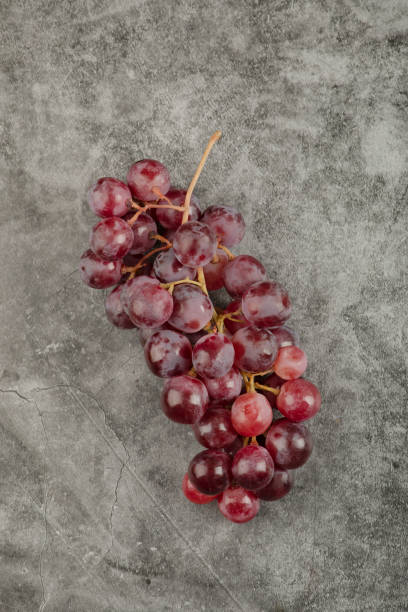 istock Cluster of red fresh ripe grapes on marble surface 1304344983