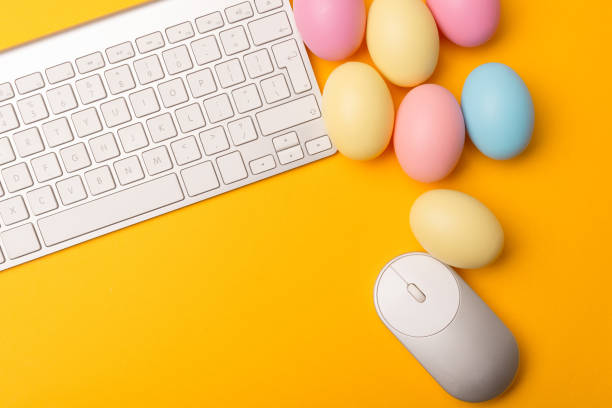 istock Close up photo of PC and many easter eggs over yellow background 1304348651