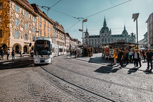 Graz, Austria- October 28, 2019: Street view. Tram on Hauptplatz square in Graz. Graz is a historic city, many ancient buildings can be seen everywhere in the city center. Graz becoming the 2003 European Capital of Culture.
