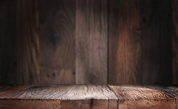 istock Empty wood table top with defocused wooden wall background. 1304348920