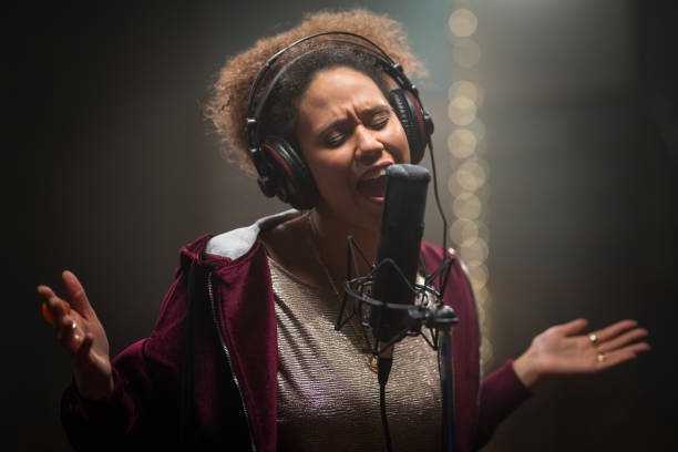 istock Female Singer Singing Into Microphone In Recording Studio 1304350095