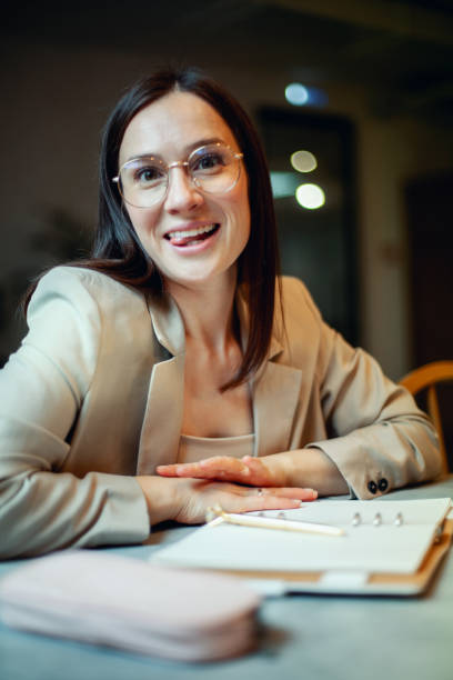 istock Beautiful young woman in suit writing her business plans while drinking coffee on break time 1304351328