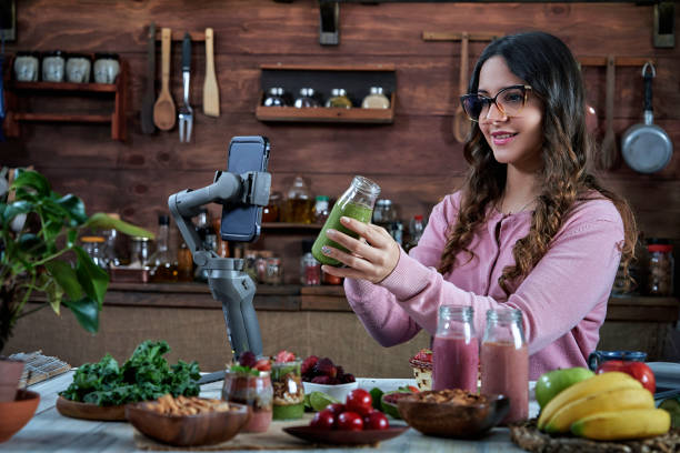 istock Hispanic young woman vlogging healthy smoothies recipes in a rustic kitchen 1304352143