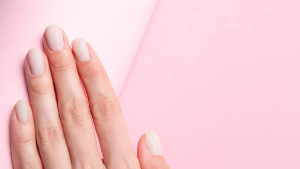 istock Matt nude nails close up on the trendy pink background with copy space 1304354486