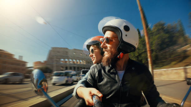 selfie scooter équitation: couple de touristes sur la moto par le colisée de rome - city bike photos et images de collection