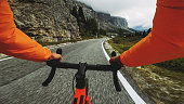 POV point of view racing bicycle riding on a road in the forest of Dolomites