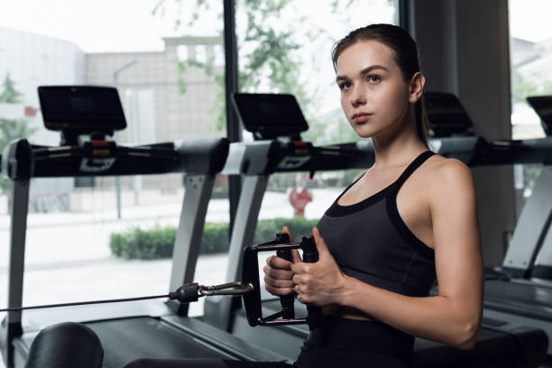 istock Woman in sportswear workout using machine in gym. 1304355527