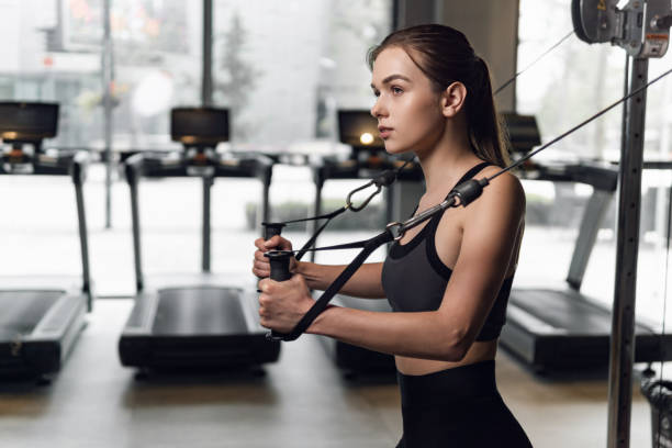 istock Woman in sportswear workout using machine in gym. 1304355556
