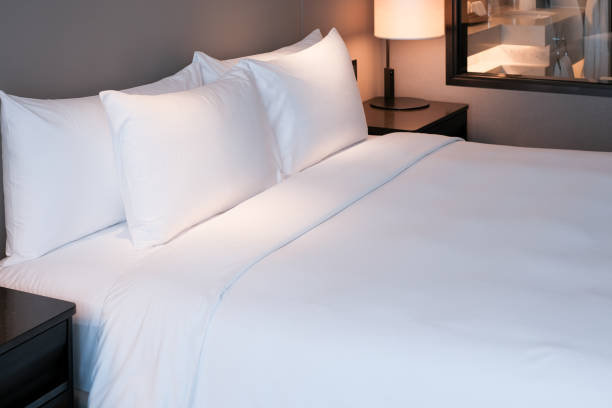 istock Clean Bedding sheets and pillow on natural wall room background. 1304356966