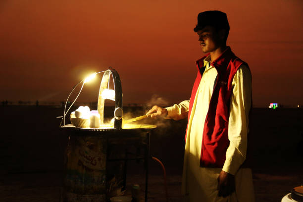 Chicken Yakhni soup stall at Clifton Beach, Karachi Karachi – Pakistan: A young adult Pakistani man selling chicken Yakhni soup with boiled eggs by Clifton beach in Karachi, Pakistan. clifton stock pictures, royalty-free photos & images