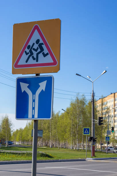 traffic signs. the direction indicator. children cross the road. - single line urban scene outdoors vertical imagens e fotografias de stock