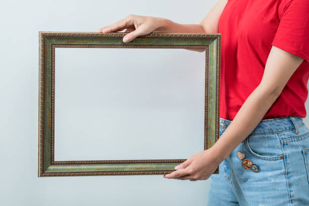 istock Female model in red shirt holding photo frames 1304364336