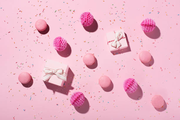istock Flat lay birthday composition with sweet cakes macaroons, sprinkles, pink gift boxes and paper decorations on pink background. 1304367489