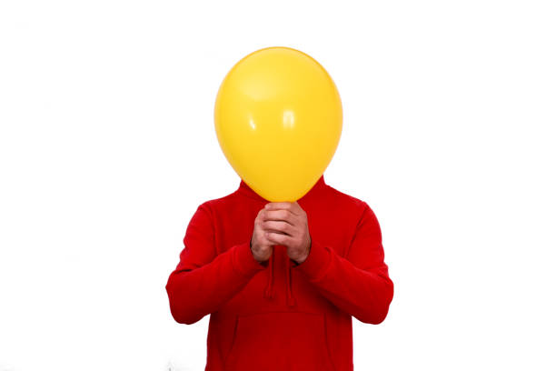 istock A man covers his face with a yellow balloon 1304368458