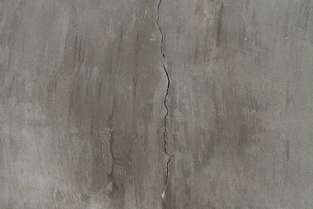 istock Cracked concrete on grey wall in the middle of frame. 1304368945