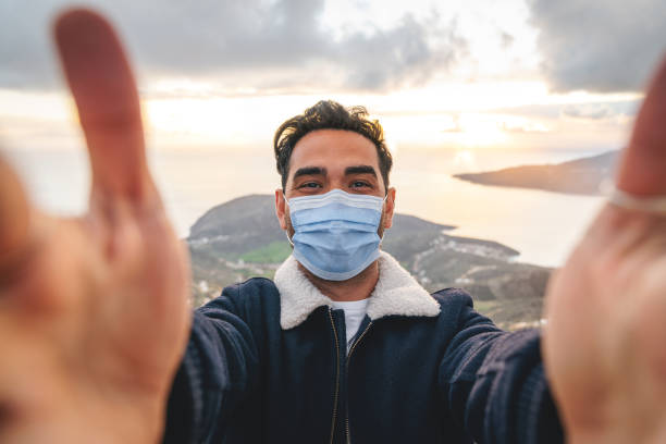 istock Young man taking selfie with a facial mask 1304369579