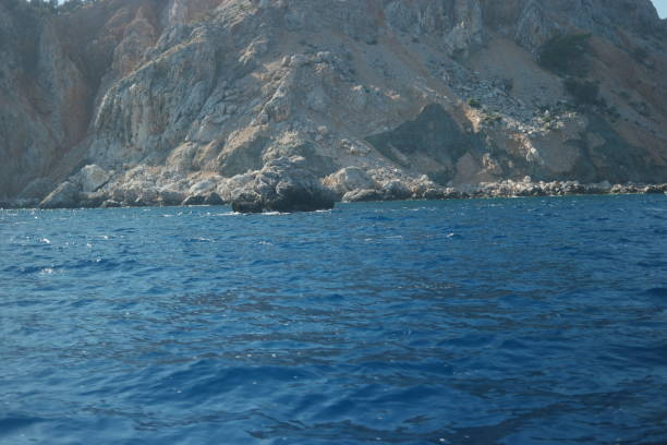 istock Rock formation in blue ocean water. 1304371164
