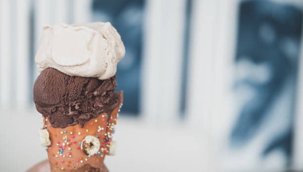 шоколадное и ванильное мороженое в вафельных конусах. селективный фокус - symmetry ice cream cone ice cream cream стоковые фото и изображения