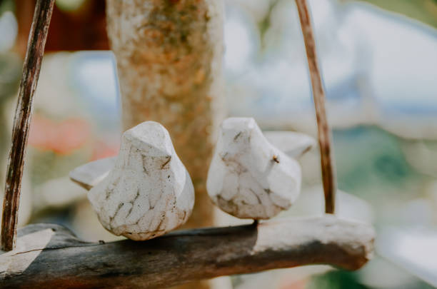 a pair of birds made of wood which is a suitable hanging decoration to decorate a tree