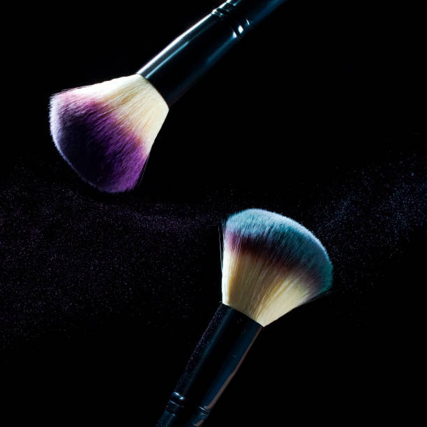 istock Cosmetics Concepts. Macro Shot of Two Professional Makeup Brushes With Colorful Eyeshadows Explosion Against Black. Square Image 1304372041