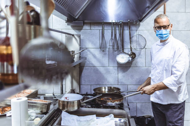istock Chef cook wearing face protective medical mask for protection from coronavirus 1304380118